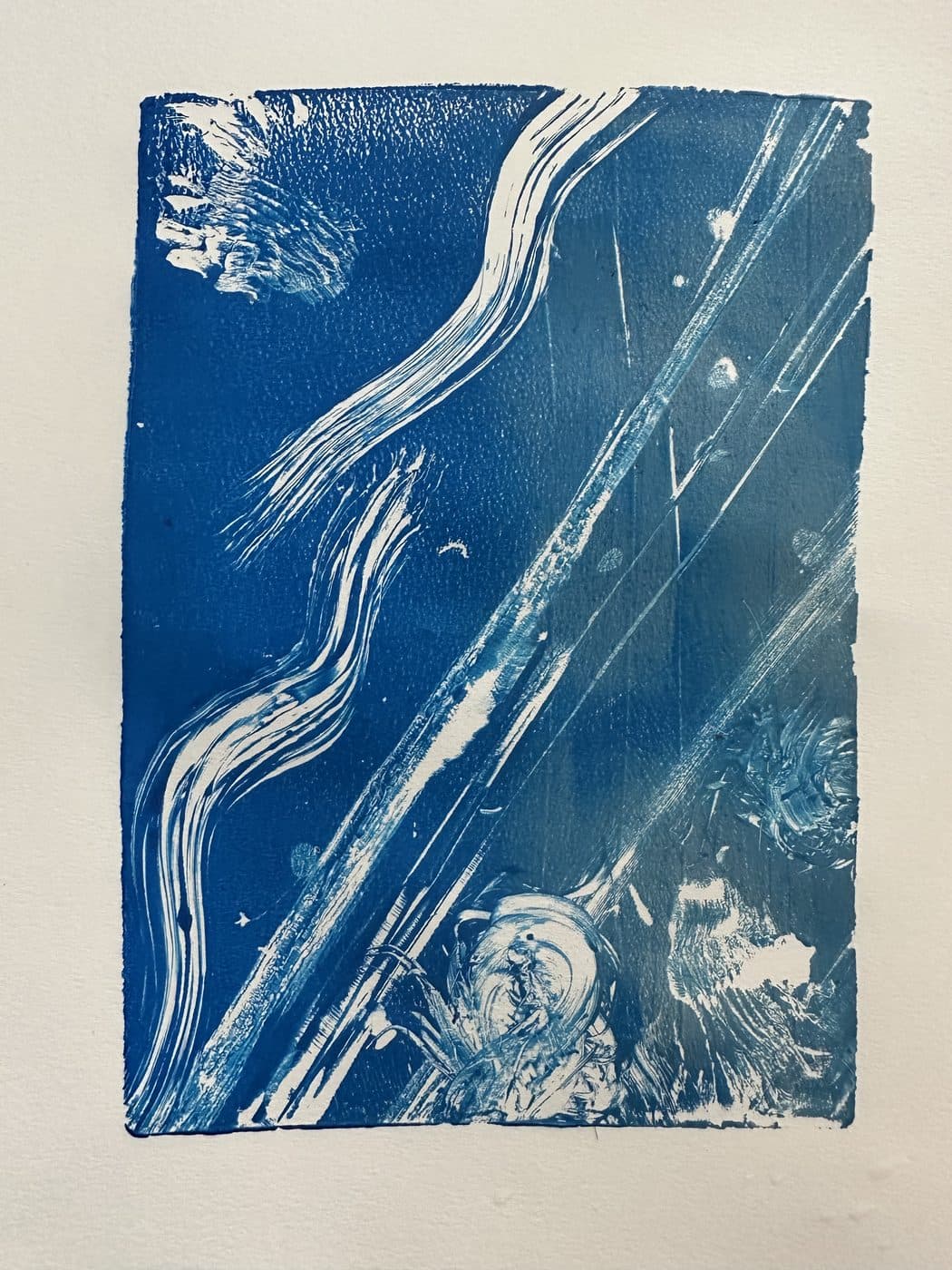 A deep blue print on paper with white streaks and swirls running diagonally like waves