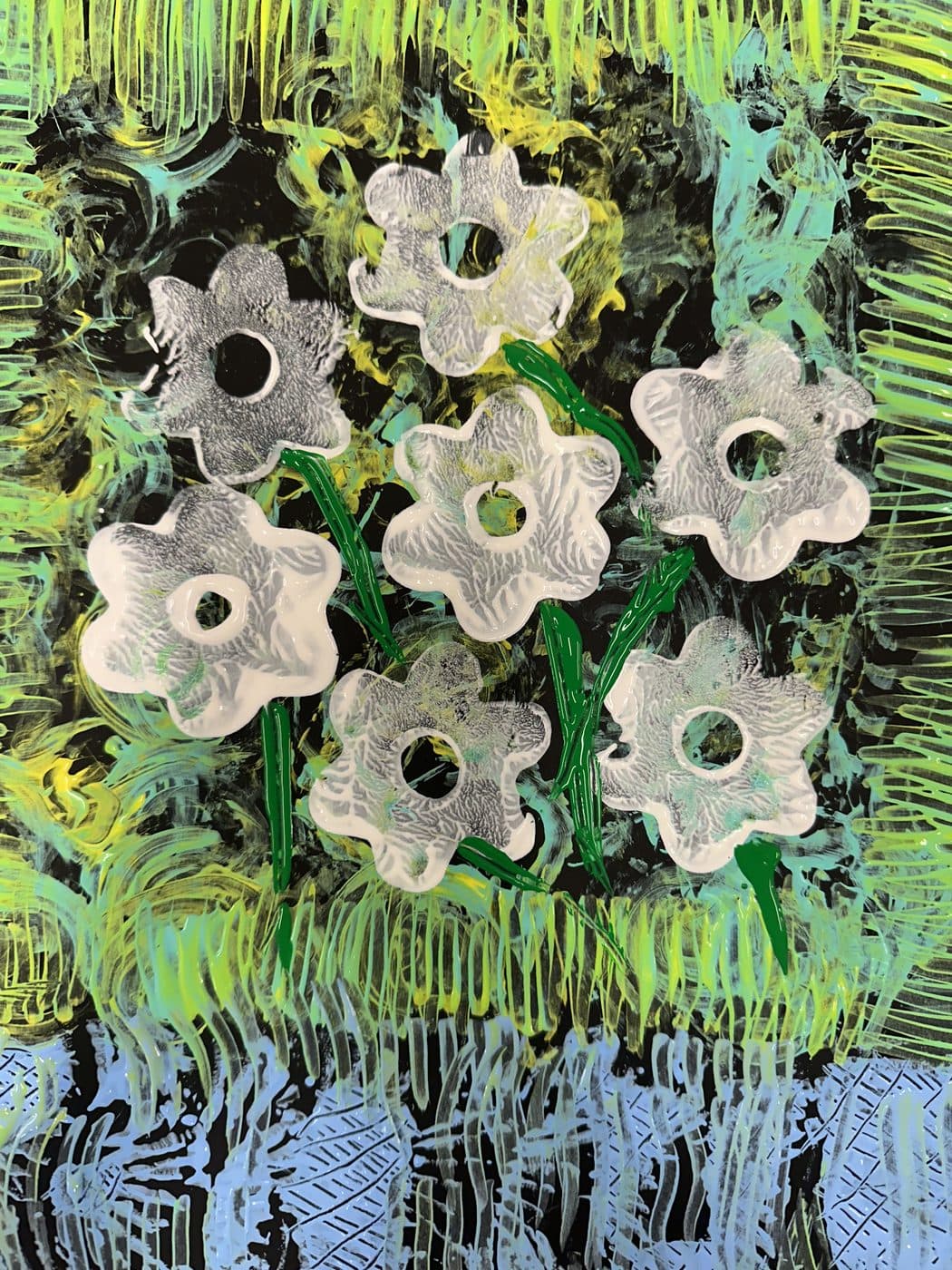 White flower shapes stamped in a grid over layered green and yellow paint strokes